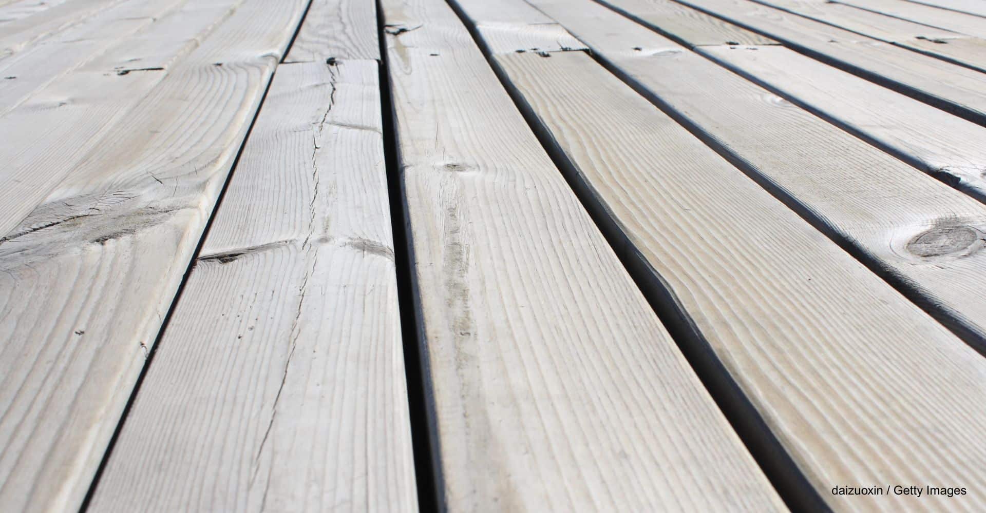 Close-up von Terrassendielen mit grauer Patina, deren Holz man entgrauen kann
