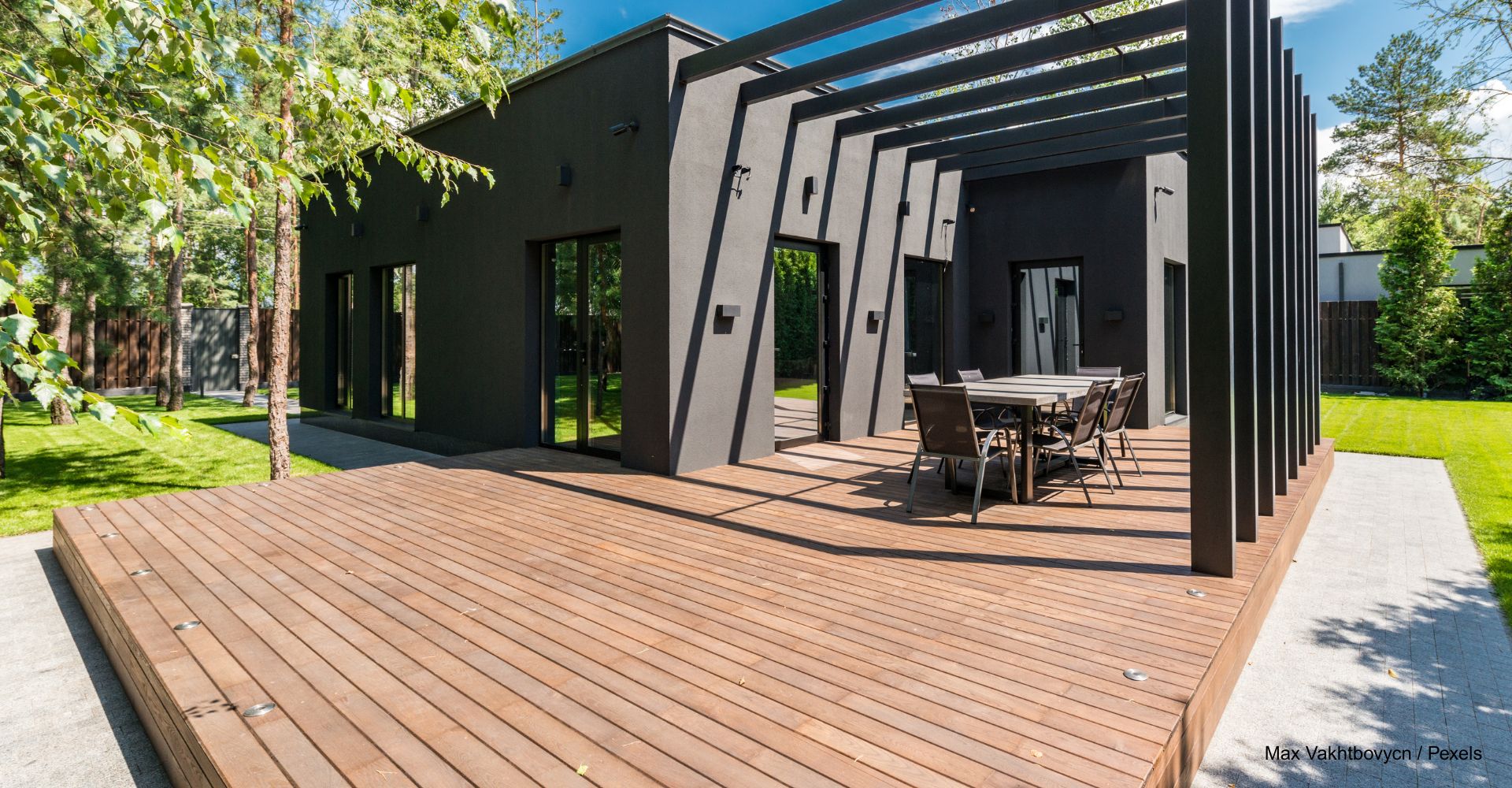 Blick auf einem moderne, frisch behandelte Holzterrasse vor einem modernen grauen Haus