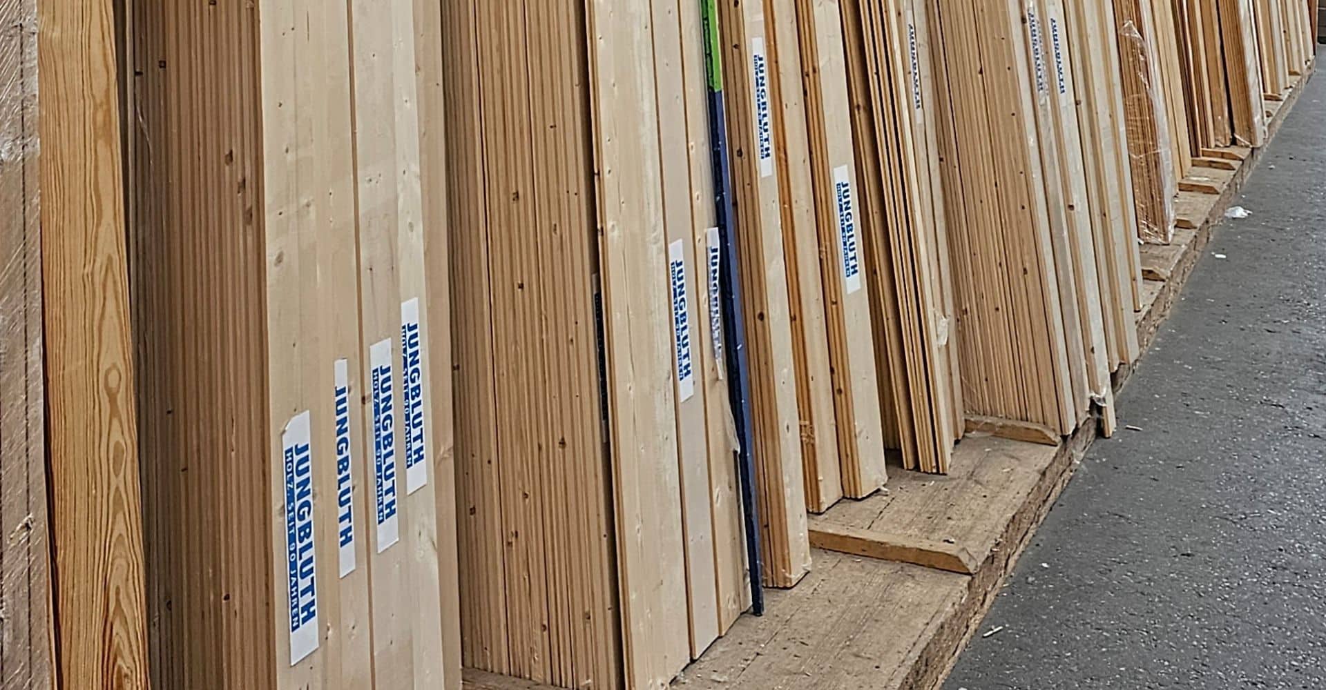 Reihe von Hölzern mit "Jungbluth"-Aufkleber in der Ausstellung im Jungbluth Holzfachmarkt Neuss